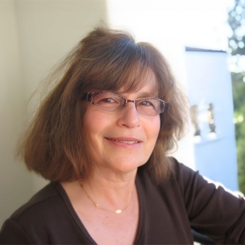 Suzanne Jill Levine stands on a balcony wearing a dark top